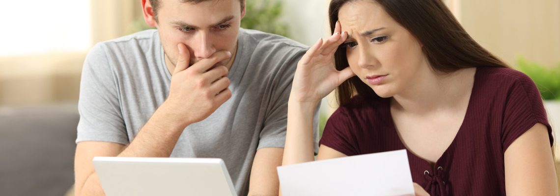 Worried,Couple,Reading,Together,A,Letter,Sitting,In,A,Desk